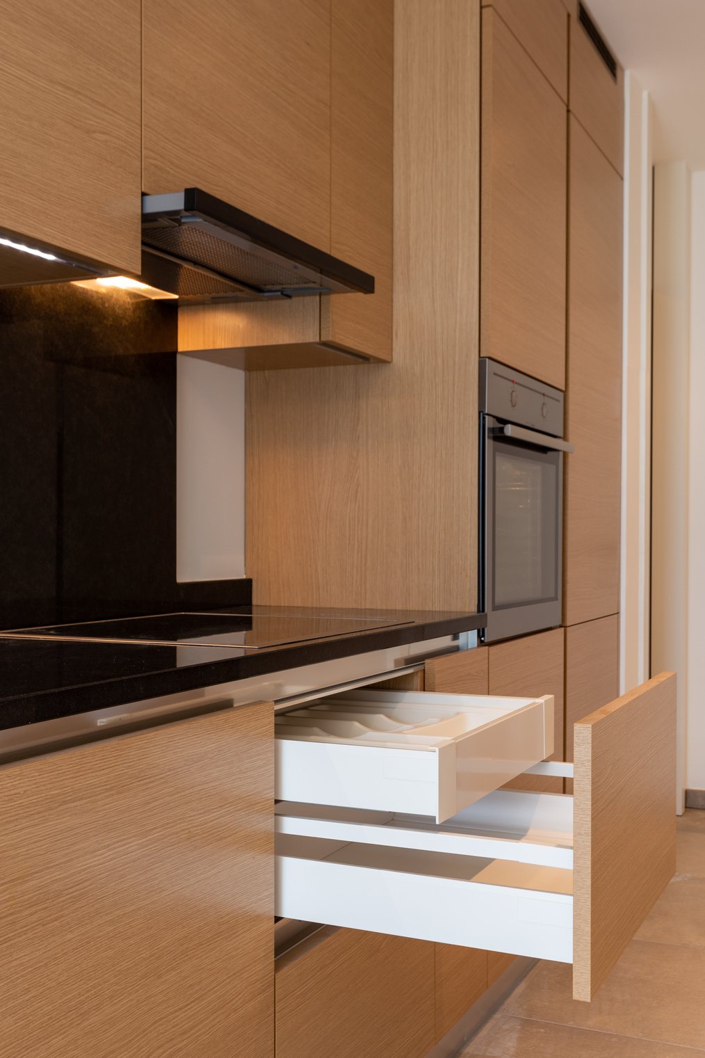 Kitchen detail with stove, hood and open drawers